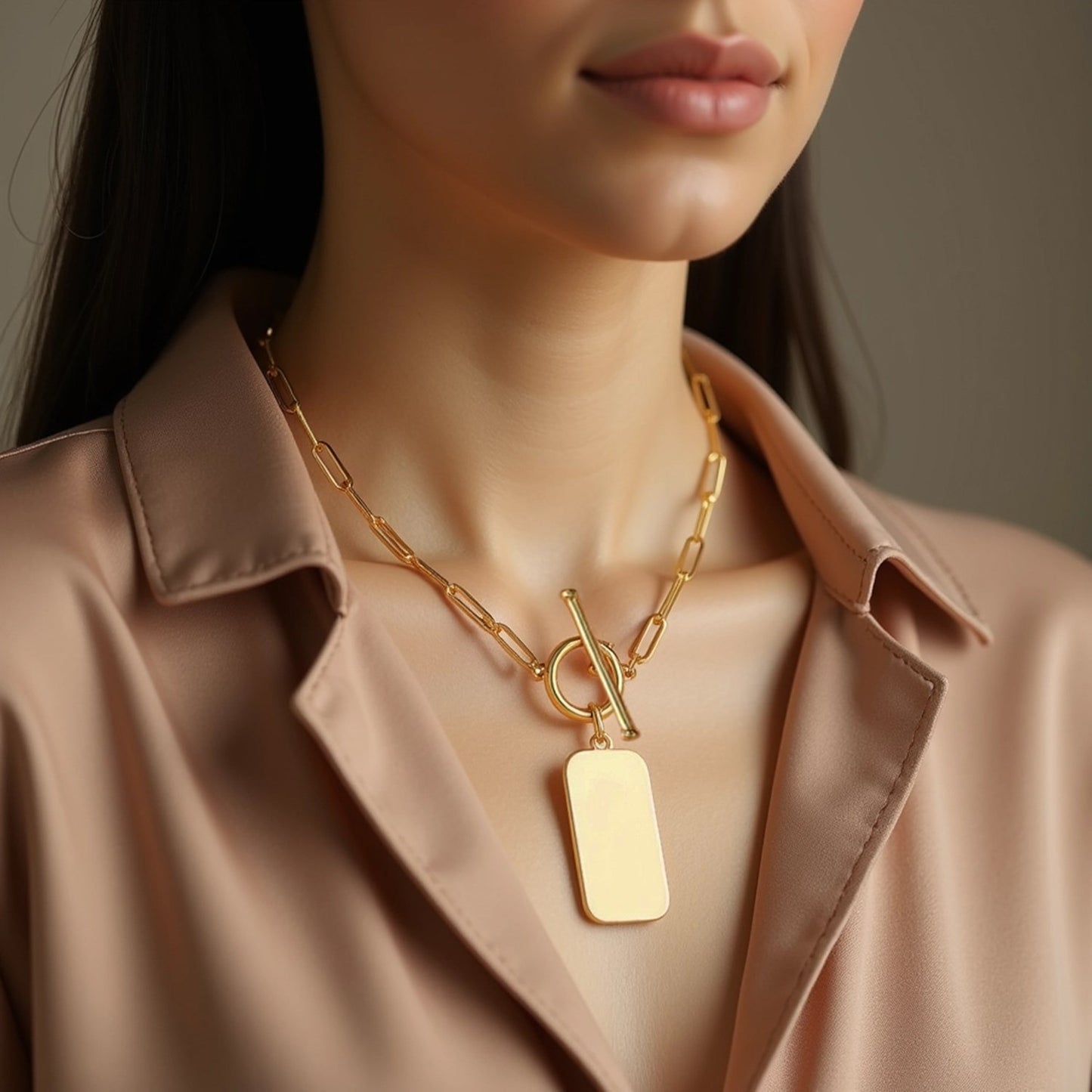 Close-up of a person wearing a gold necklace with a tag pendant.