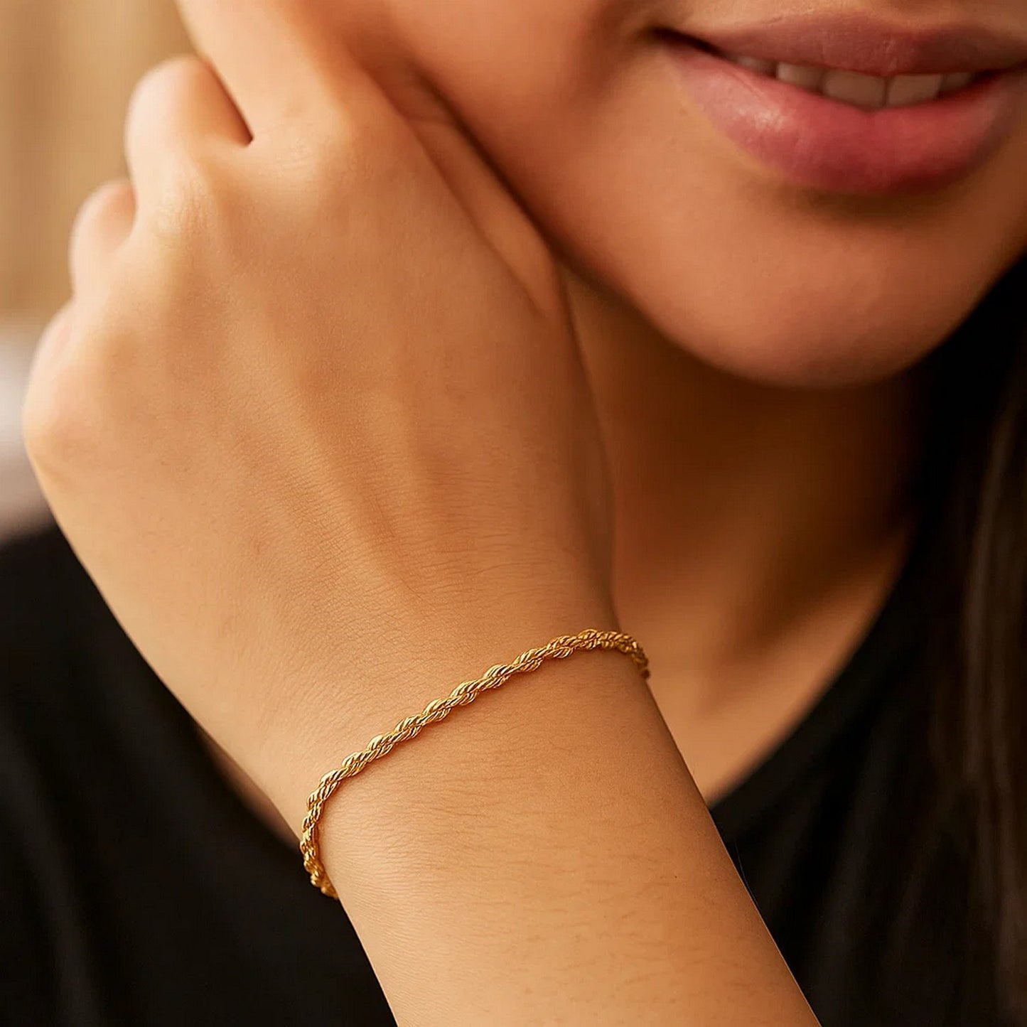 Close-up of a person wearing a gold bracelet on their wrist.