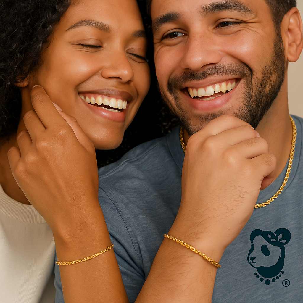 Couple smiling with gold jewelry, one wearing a blue shirt with a logo.