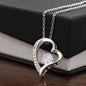 Heart-shaped Forever Love Necklace with a cubic zirconia centerpiece, available in 14K white gold or 18K yellow gold finish, displayed on a black and white gift box.