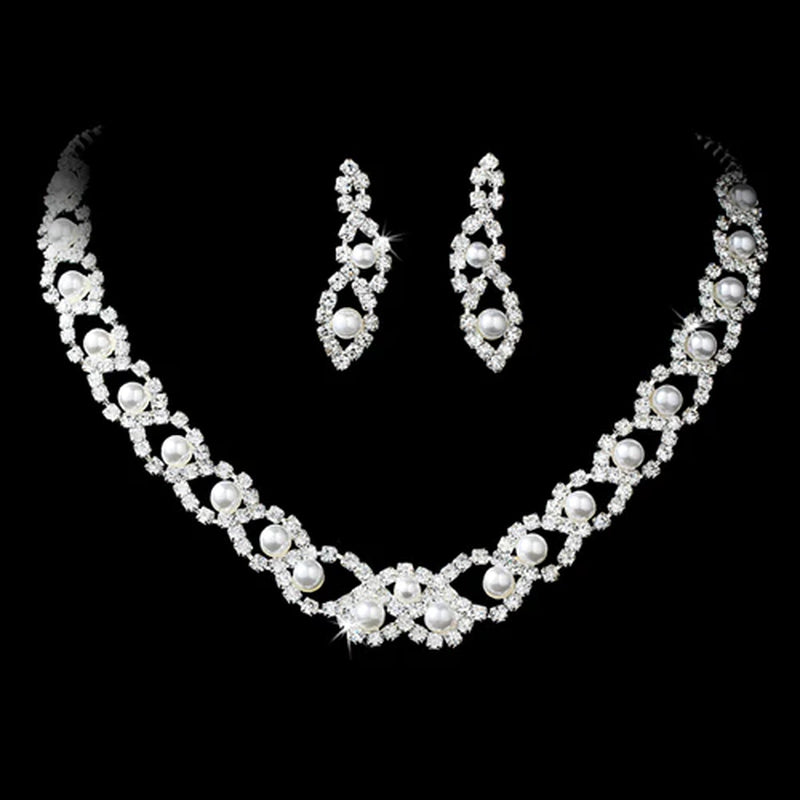 Elegant pearl and rhinestone bridal necklace and earring set displayed on black velvet