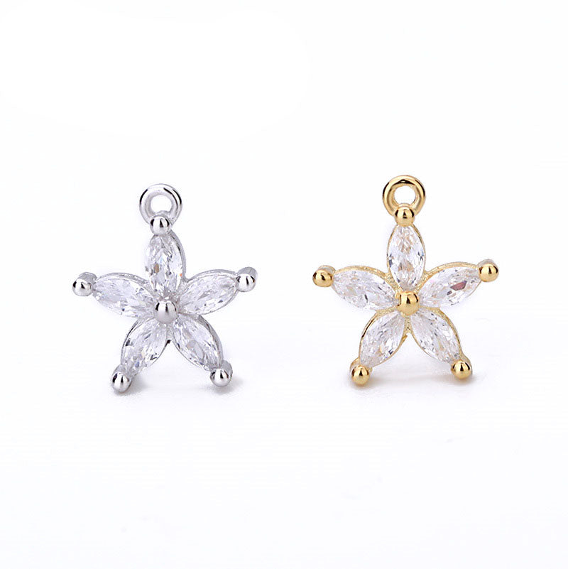 Star-shaped jewelry pendants in gold and silver on a white background