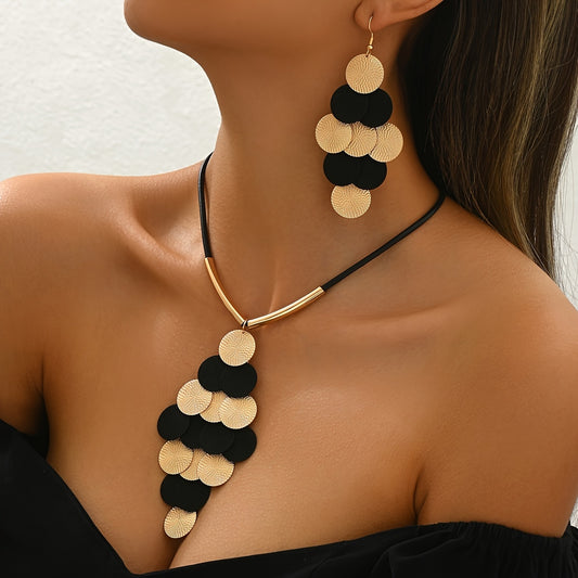Woman wearing 14K gold black gothic statement jewelry set with a layered disc necklace and matching chandelier earrings.