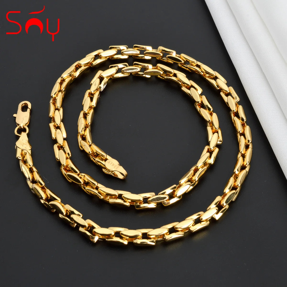 Bold Dubai-style gold chain laid flat on a dark background