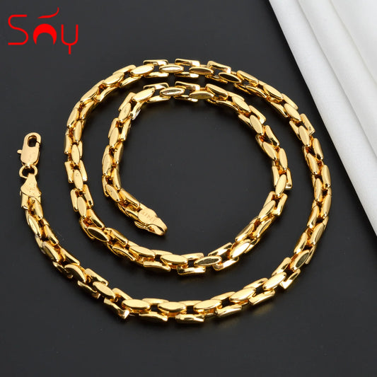 Bold Dubai-style gold chain laid flat on a dark background