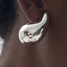 Woman wearing a white tank top against a plain background