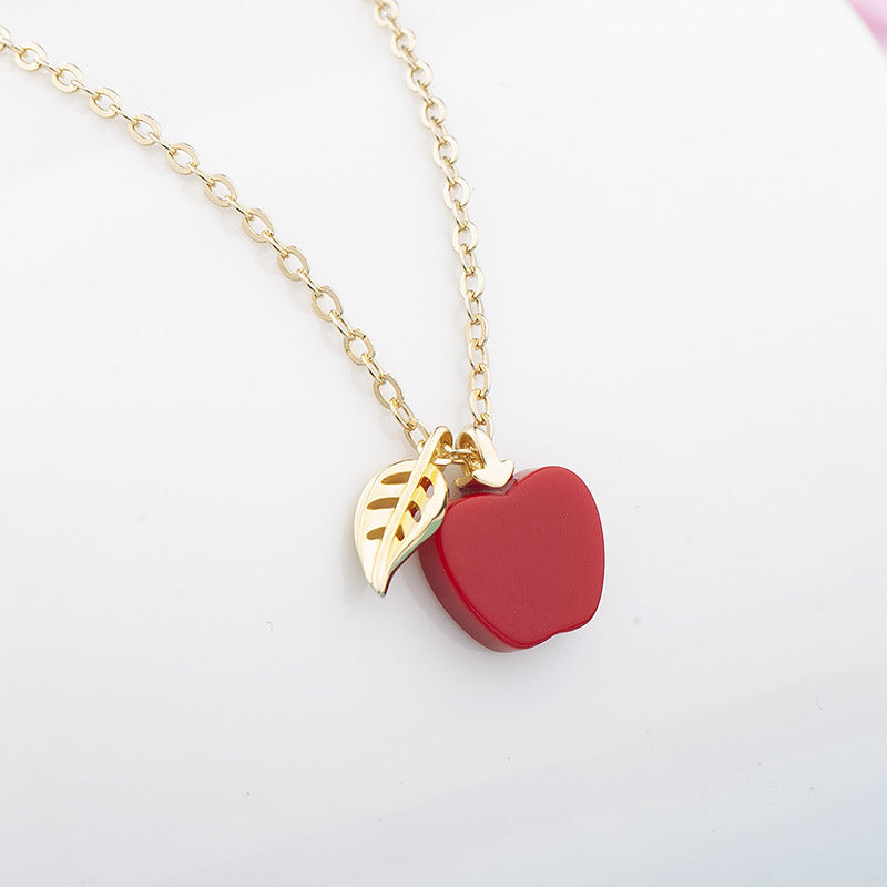 Necklace with a red heart pendant and gold chain on a white background