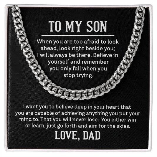 Men's silver or gold Cuban chain with a classic high-polish finish, displayed on a dark background.