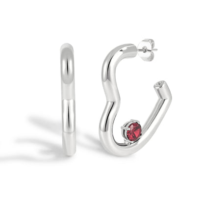 Silver hoop earrings with a red gemstone on a white background
