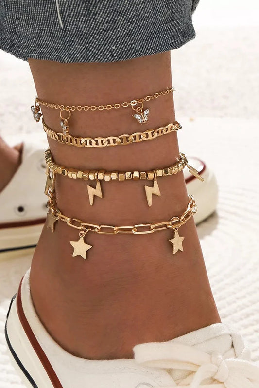 "Boho gold anklet set layered with chains, beads, and charms on ankle in casual summer look"
