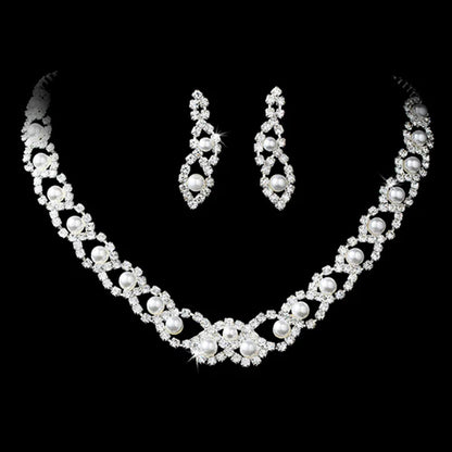 Elegant pearl and rhinestone bridal necklace and earring set displayed on black velvet