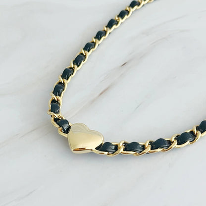 Trendy gold-plated chain necklace with a heart charm and black woven accents.
